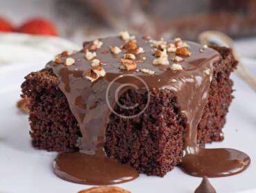 Soft sponge cake with dark chocolate topping and nuts